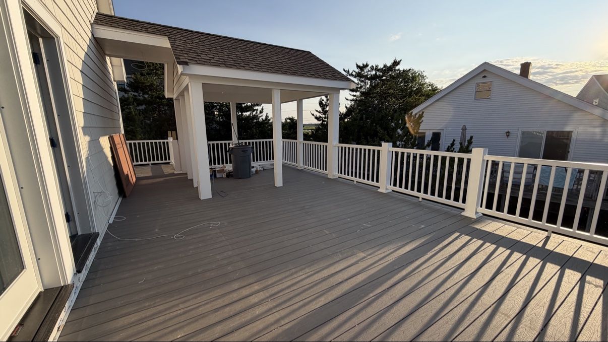 Finished covered deck with white railings at sunset
