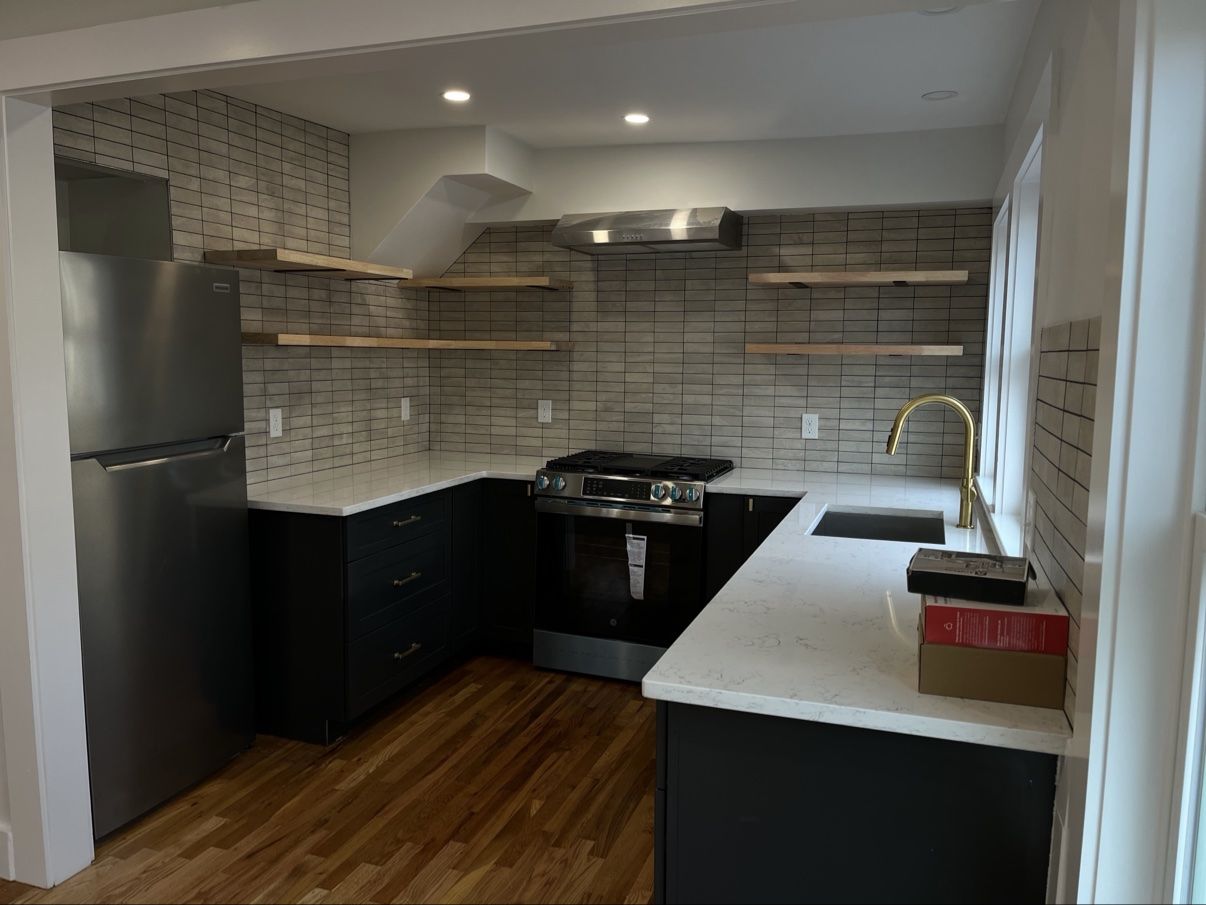 Finished two-tone kitchen with open shelves and tiled backsplash